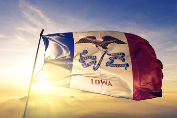 Iowa state of United States flag waving on the top sunrise mist fog - obrazy, fototapety, plakaty