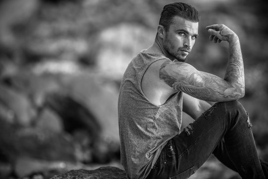 Model Guy sitting on the rock at beach