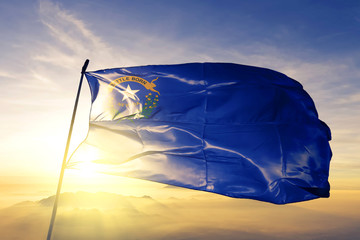Nevada state of United States flag waving on the top sunrise mist fog - obrazy, fototapety, plakaty