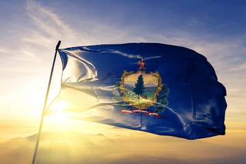 Vermont state of United States flag waving on the top sunrise mist fog