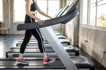 Young Asian woman exercising on treadmill at a gym