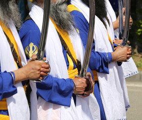bearded Sikh men with swords during a parade