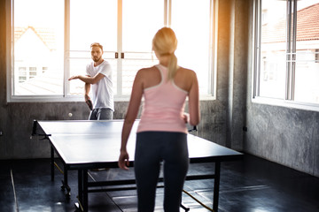 couples playing ping pong (table tennis) in gym