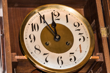 part of an antique clock at five minutes till 12