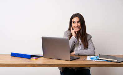 Business woman in a office thinking an idea while looking up