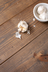 Garlic Bulb and Cloves on a Wooden Table; One Isolated in Front