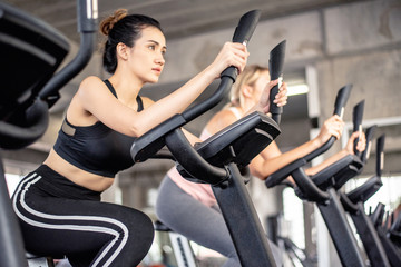 Portrait of young woman on exercise bike in fitness club