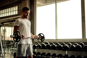 Portrait Caucasian handsome young man Are building muscles with exercise machines,healthy sports lifestyle, Fitness concept