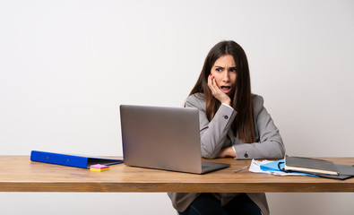 Business woman in a office surprised and shocked while looking right