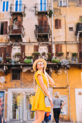 girl in yellow dress, sunglasses and boater poses on the streets