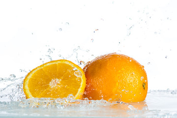 Fototapeta na wymiar Orange and grapefruit in a spray of water on a white background