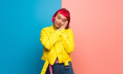 Young woman with yellow jacket making sleep gesture in dorable expression