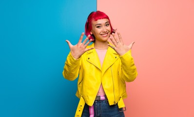 Young woman with yellow jacket counting ten with fingers