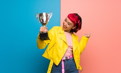 Young woman with yellow jacket holding a trophy