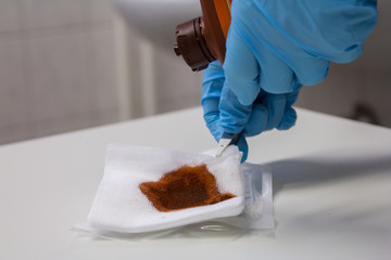a doctor dribbles antibacterial fluid on a compress