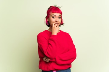Young woman with red sweater having doubts while looking up