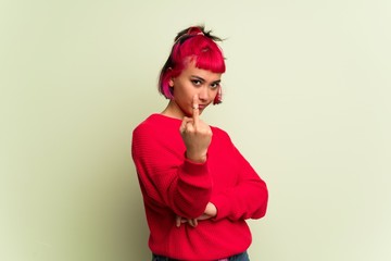 Young woman with red sweater making horn gesture