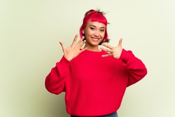 Young woman with red sweater counting nine with fingers