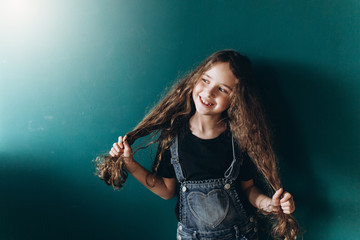 Teen pretty cute caucasian girl posing at home on green wall background. Beauty, childhood, emotions concept