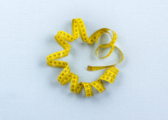 Flat lay singl measuring tape on blue background. Weight loss concept. Top view.