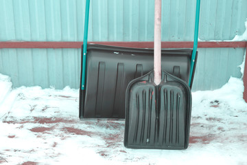 Snow shovels standing in the yard. Background.