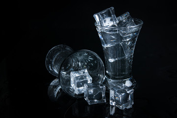 Russian vodka shot with ice on black background