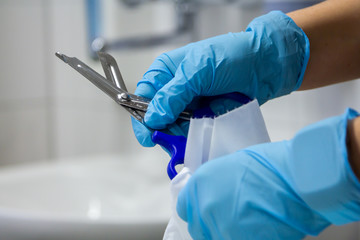 Hands with blue gloves disinfect  a scissors