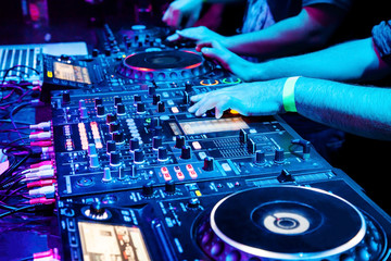 Fototapeta na wymiar Dj mixes the track in nightclub at party. Body part on the DJ's music control panel