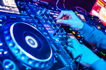 Dj mixes the track in nightclub at party. Body part on the DJ's music control panel