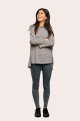 A full-length shot of a Teenager girl with striped shirt looking up while smiling over isolated background