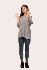 A full-length shot of a Teenager girl with striped shirt nervous and scared stretching hands to the front over isolated background