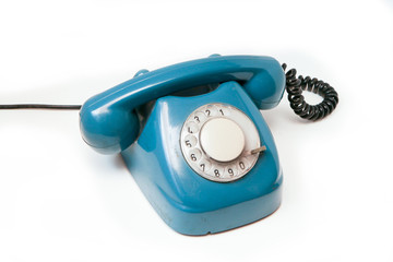 A blue old retro rotary mechanical phone isolated on a white background.