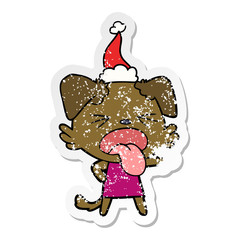 distressed sticker cartoon of a disgusted dog wearing santa hat