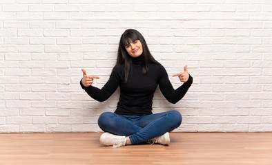 Woman sitting on the floor proud and self-satisfied