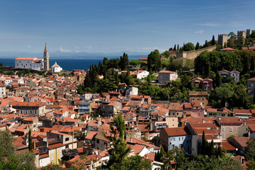 Piran Slovenia on Gulf of Trieste Adriatic sea with St George's Catholic Cathedral to the crenellated town walls with Kanin Mountains