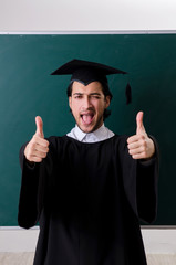 Graduate student in front of green board 