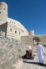 an Arab man going to the gate of an ancient fortress
