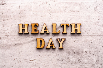 Inscription HEALTH DAY in wooden letters on a light background
