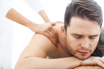 Fototapeta na wymiar Handsome man having massage in spa salon