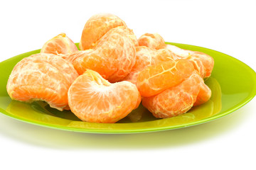 Peeled slices of mandarin on a green plate on a white background.