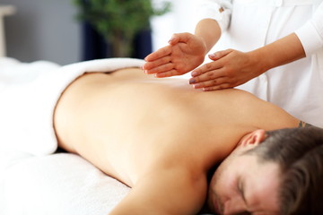 Obraz na płótnie Canvas Handsome man having massage in spa salon