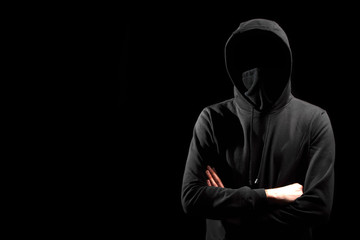 Fototapeta na wymiar faceless man in hoodie standing isolated on black