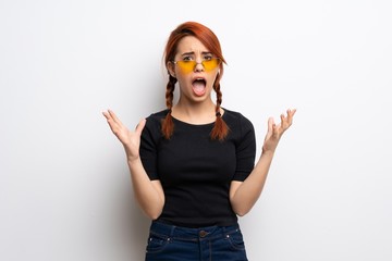 Young redhead woman over white wall frustrated by a bad situation