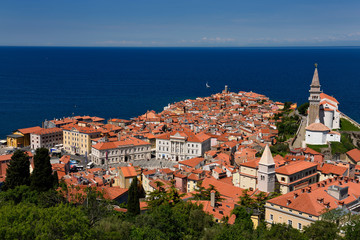 Fototapeta premium Cape Madonna at Point of Piran Slovenia on blue Adriatic Sea with Tartini Square courthouse City Hall and St George's Catholic church