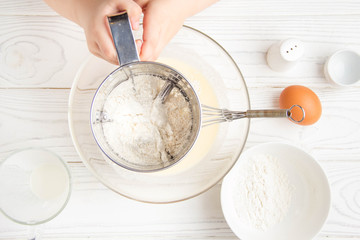 Baby little hands sifting the flour, stirring the dough for pancakes, cooking in the kitchen