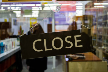 A sign with an inscription on the glass door of the store