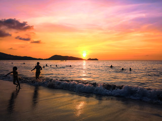 Fototapeta na wymiar the sea at sunset and silhouettes of tourists