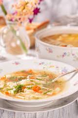 Plate with fresh hot soup on the table. Porcelain dishes.