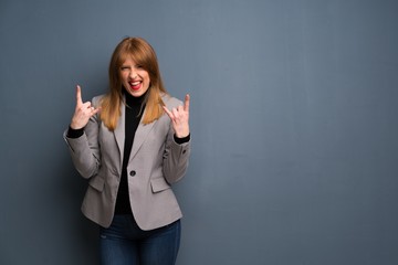 Redhead business woman making rock gesture