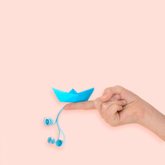 Girl holds paper boat with wave on her finger
